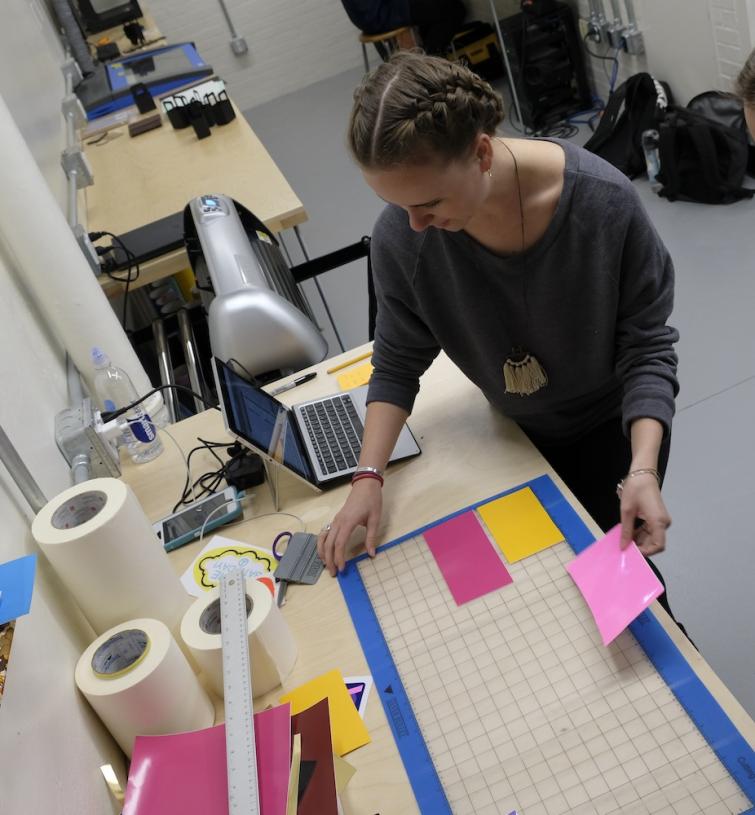 Students layout print materials on a grid