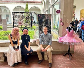 Miyabi Kawai and Casey Yin sit with faculty researcher Andrew Mugler in front of their artworks