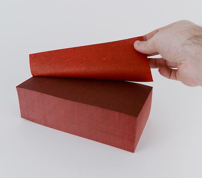 Red block with red paper peeled from the top